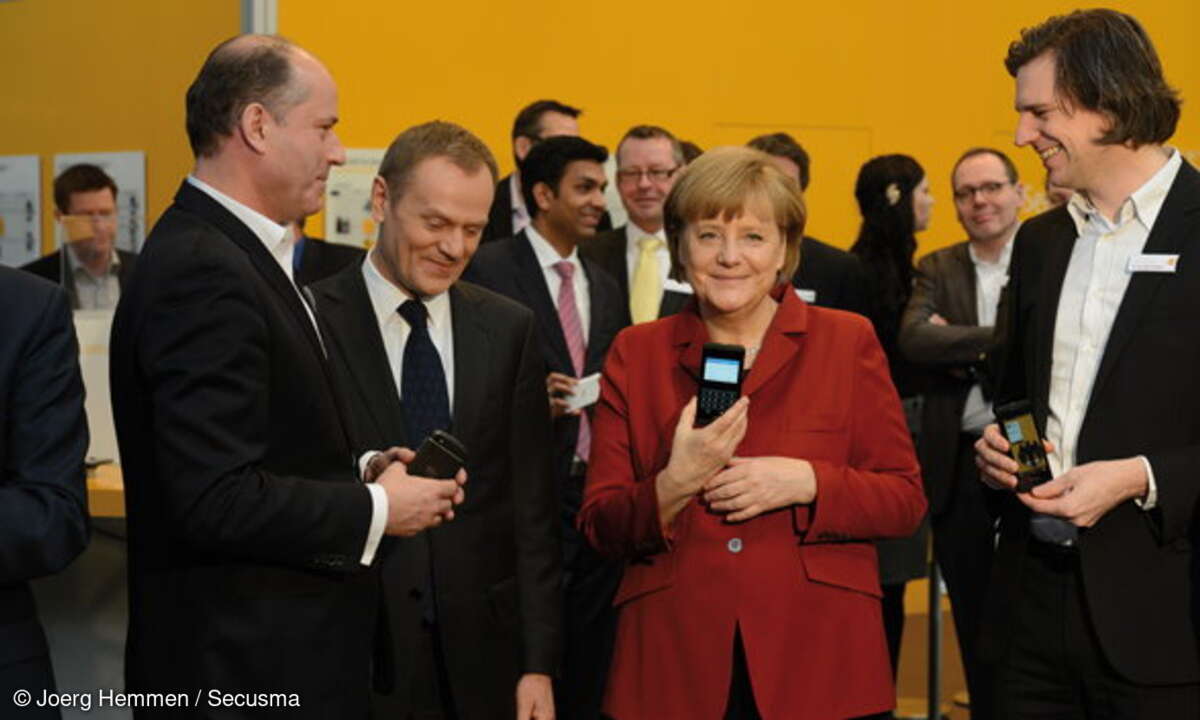 Bundeskanzlerin Angela Merkel mit einem abhörsicheren Blackberry am Stand von Secusmart beim Eröffnungsrundgang auf der CeBIT 2013