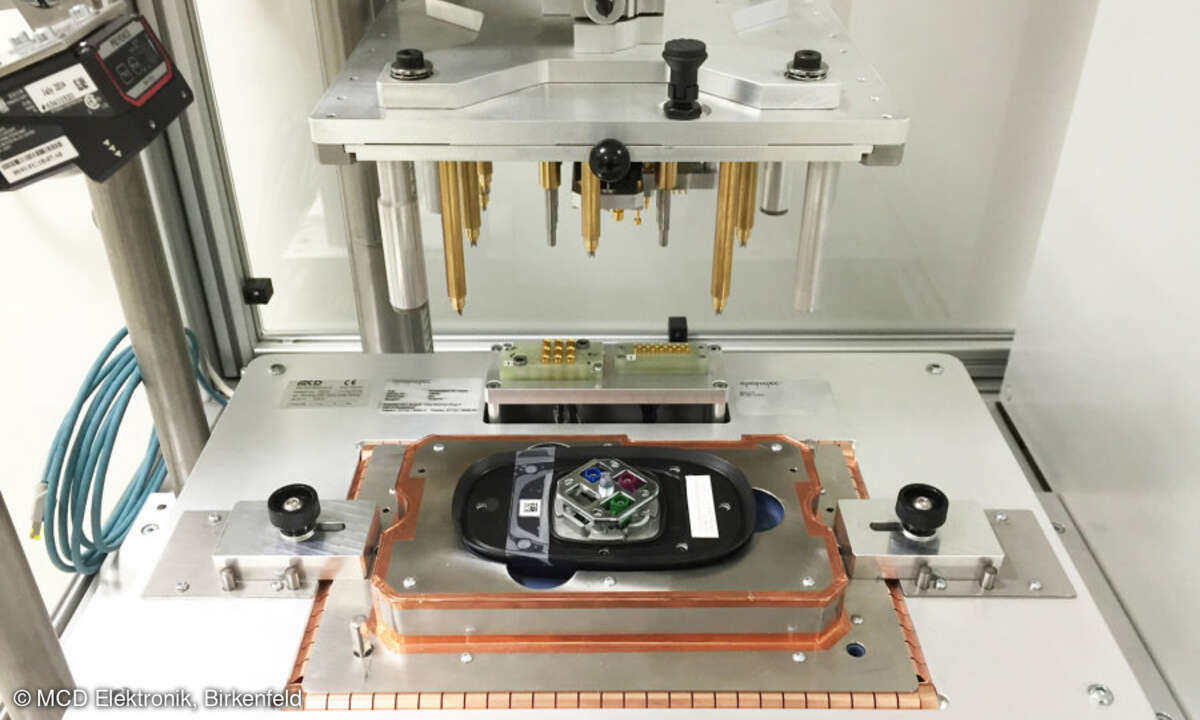 Die Antenne (zu sehen sind die Anschlüsse an der Unterseite) ist bereits in den Prüfadapter eingelegt, die Kontakteinheit mit den HF-Kontaktstiften ist bereit zum Herunterfahren.