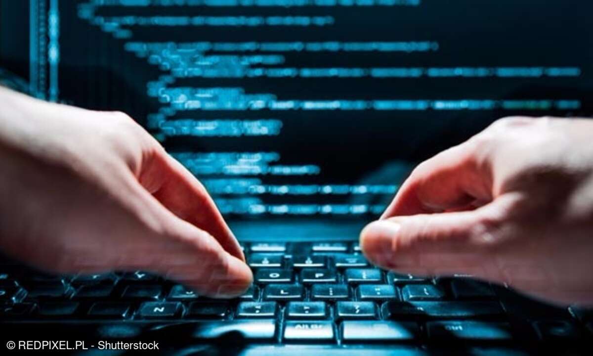Hände auf Tastatur mit Codezeilen im Hintergrund