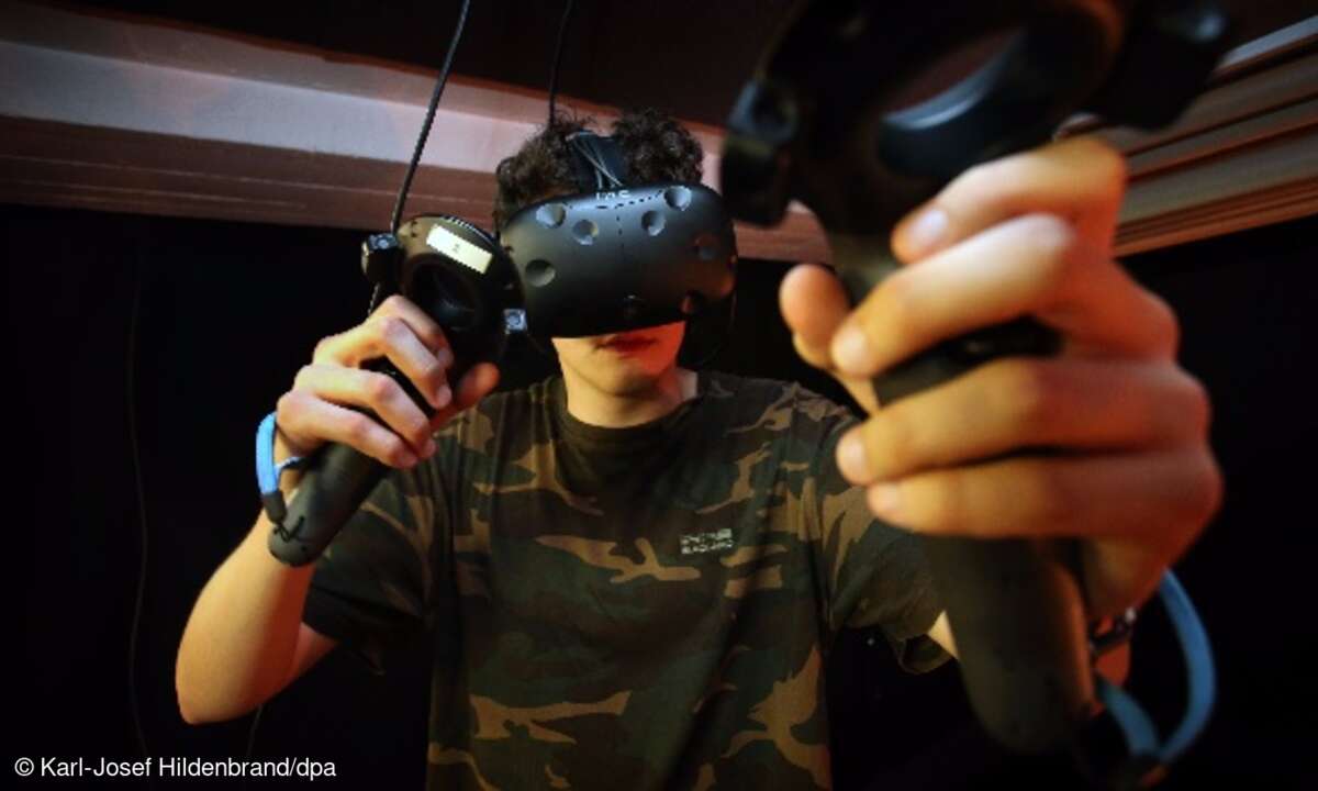 Ein junger Mann taucht in einem Virtual-Reality-Raum in Immenstadt (Bayern) mittels einer VR-Brille in eine virtuelle Welt ein.