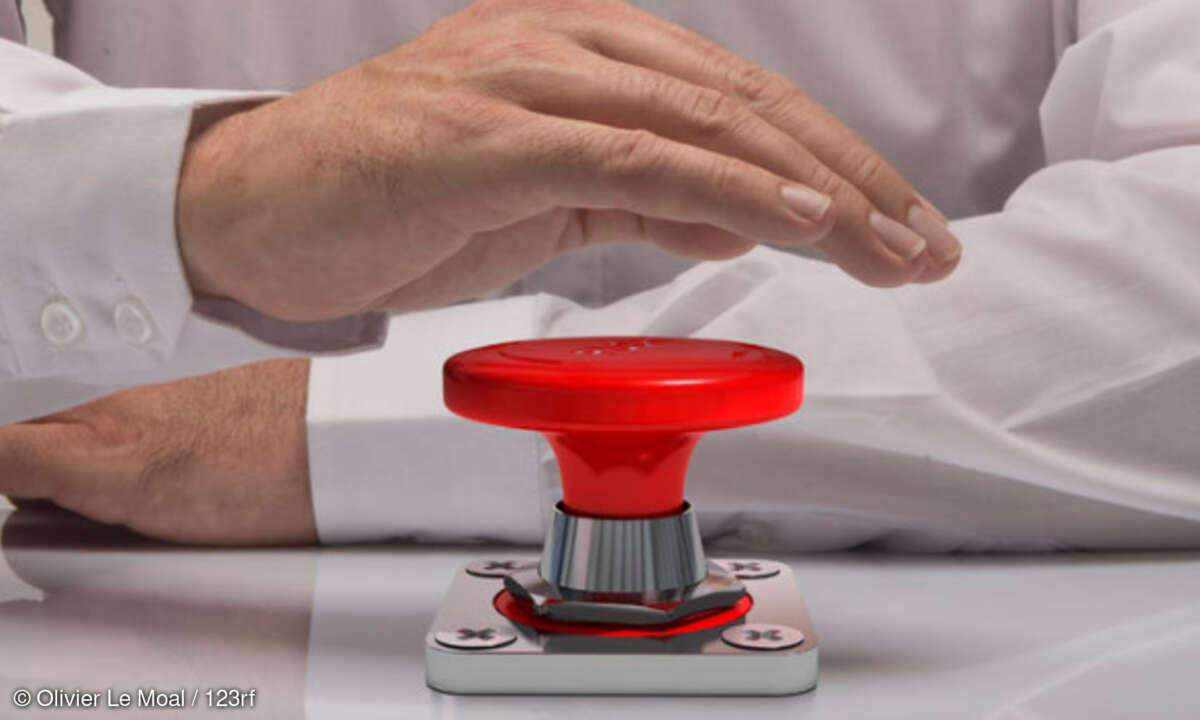 Hand drückt großen roten Knopf