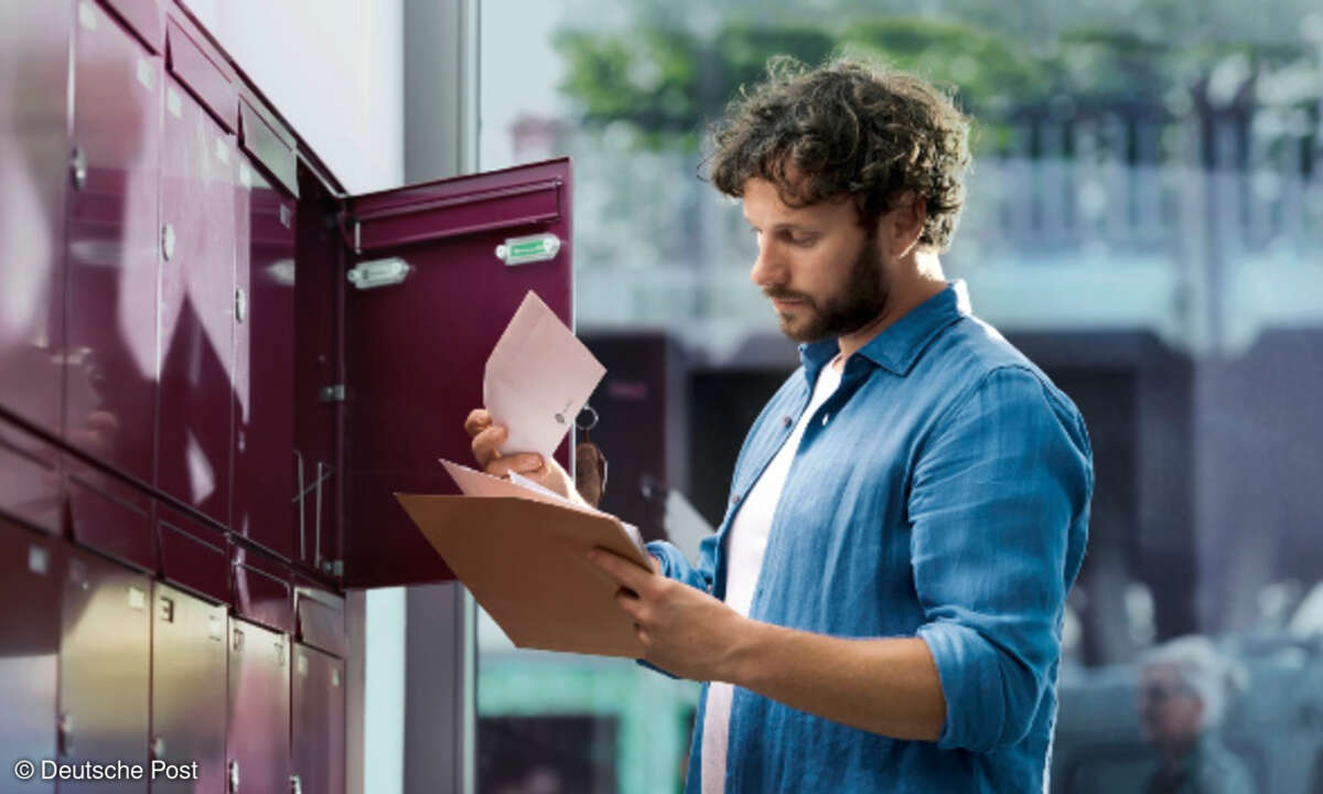 Mann holt Briefe aus Briefkasten