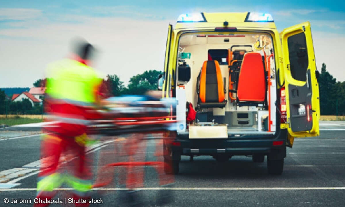 Rettungsassistent läuft auf Notarztwagen zu