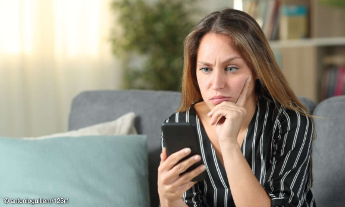 Frau guckt skeptisch mit Smartphone in Hand