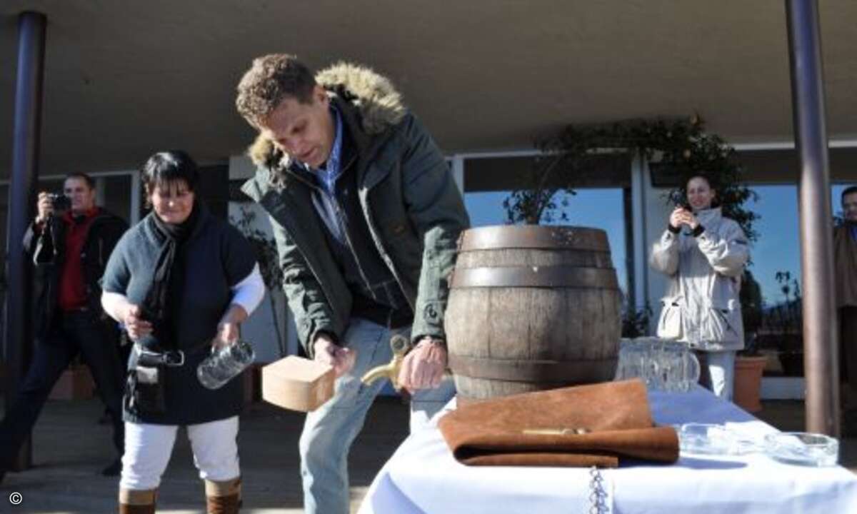 Ozapft is! CMP-WEKA-Chef Jörg Mühle sticht ein Fass Bier ganz sauber auf der Kampenwand-Hütte an
