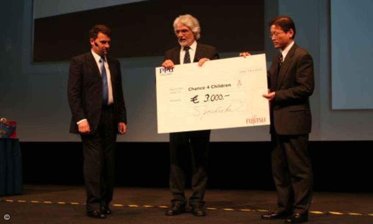 Mike Nelson, General Manager und Sho. I. Yoshioka, Vice President von PFU überreichen Manfred Franke dem Gründer von Chance 4 Children einen Scheck über 3.000 Euro