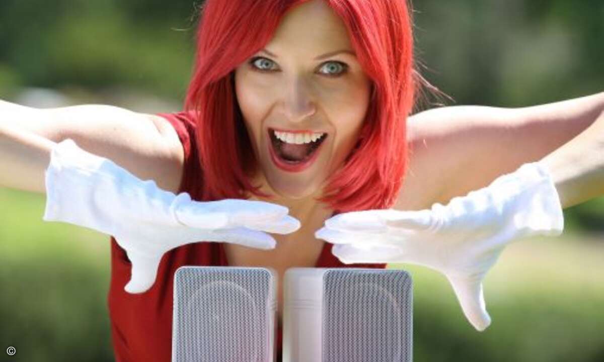 Mit Samthandschuhen fasst Miss IFA die edel designten ELAC 301.2 Mini-Lautsprecher an.