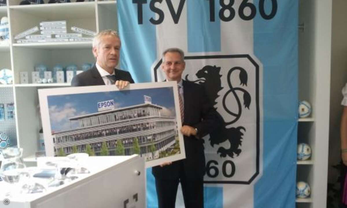 Henning Ohlsson übergibt das Eröffnungsgeschenk von Epson an Dietmar Gröbl