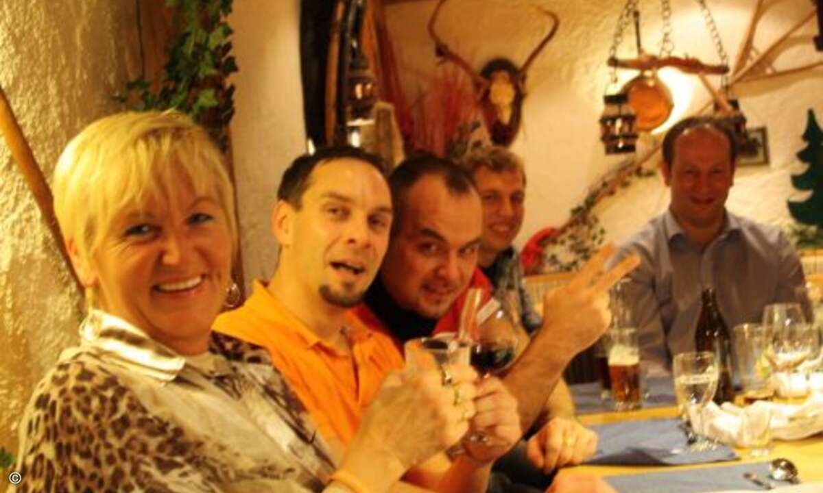 Nach dem Essen in gemütlicher Runde: Kunden und Mitarbeiter von ECOM beim bayerischen Abend mit zünftiger Volksmusik