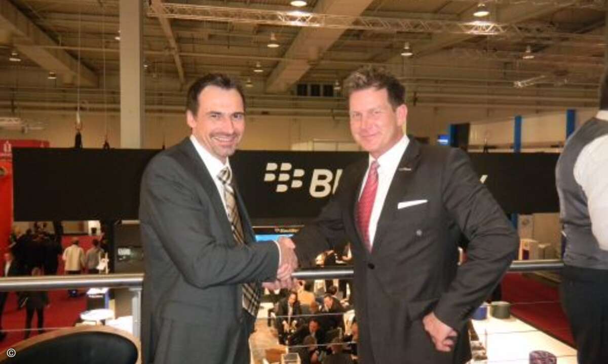 Torsten Belverato (b.kom) und Andreas Sander (Kosatec) beim Handshake auf der Kosatec-Standparty.