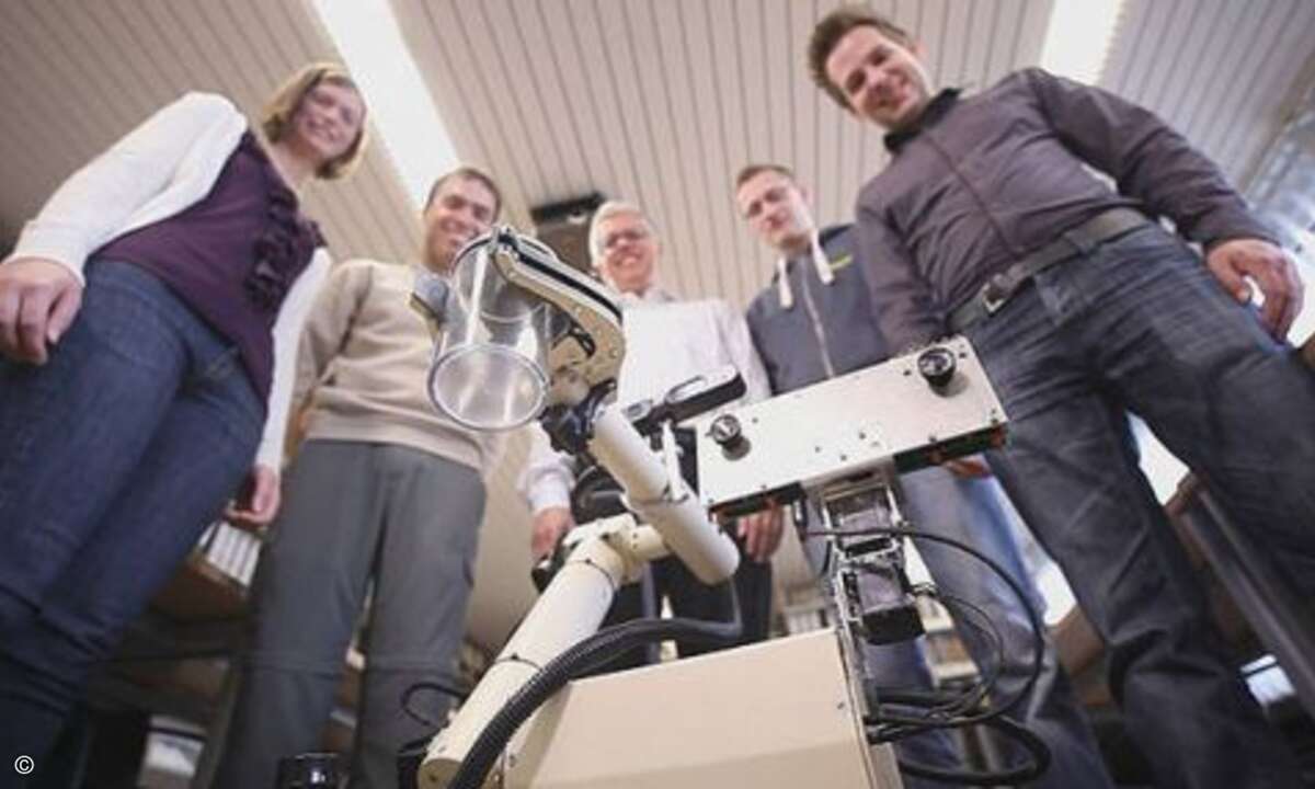 ...reicht seinen Entwicklern, Spezialisten aus der Abteilung Entwurf integrierter Systeme des Instituts für Theoretische Informatik, schon mal das Wasser. Er soll den Erfolg beim SpaceBot Cup sichern. (Bild: Deutsches Zentrum für Luft- und Raumfahrt,