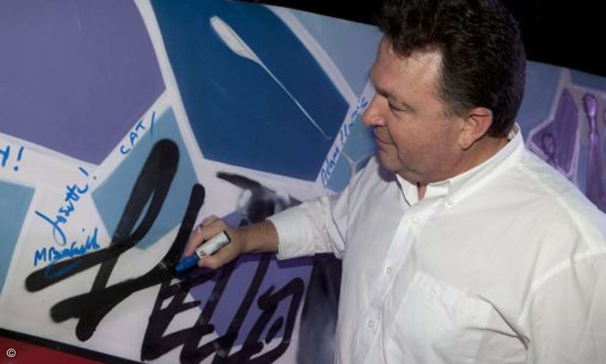 CEO Mark Cattini beim Signieren der Graffitiwand auf der Autotask Community Live in Barcelona. (Bild: Autotask)