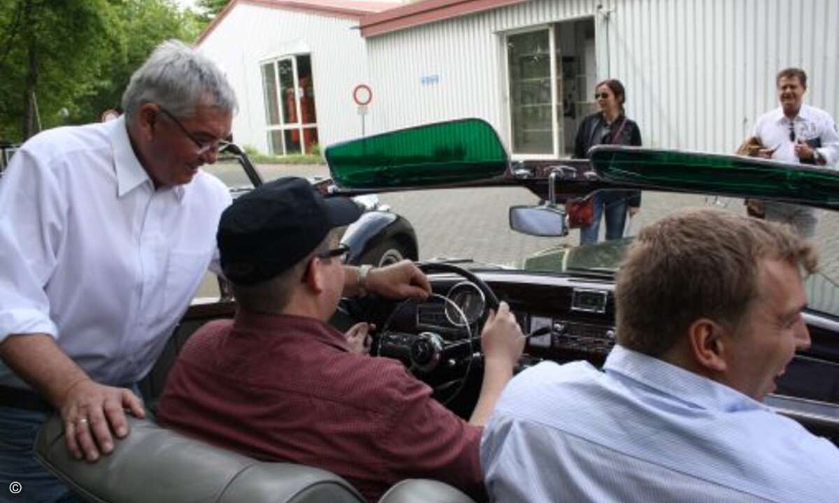 Gar nicht so einfach zu bedienen: Marcus Rein wird in den Mercedes 300 S Cabrio eingewiesen... (Bild: Ecom)