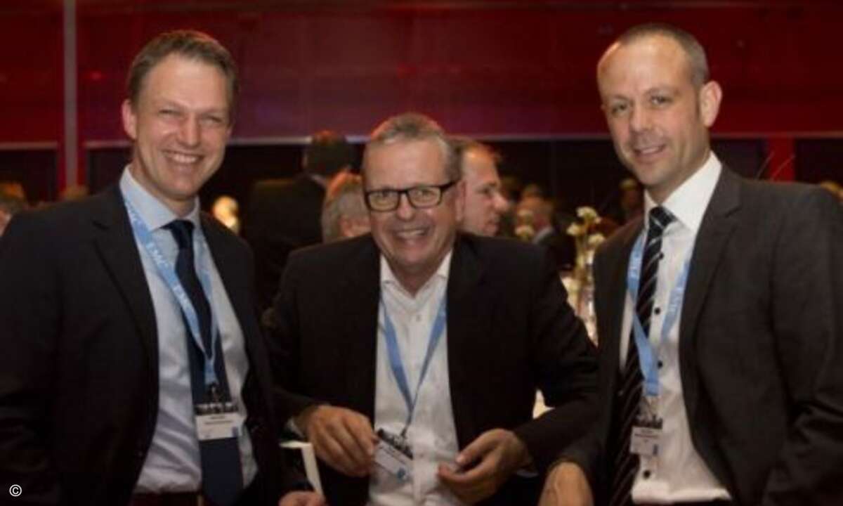 Die Dimension Data-Mitarbeiter Sönke Weerts (links) und Andre Kiehne nehmen Dietmar Vad von EMC in die Mitte