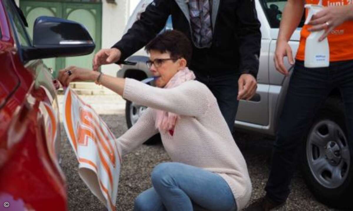 Konzentration beim Aufbringen der Rallye-Aufkleber auf die Fahrzeuge (Foto: CRN)