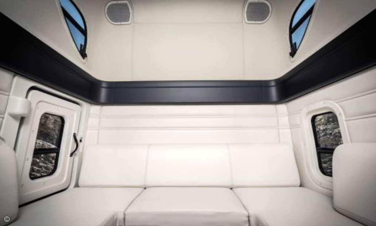 Der Fahrer zieht sich dann einfach zurück in seine Schlafkoje, die eher aussieht wie eine gemütliche Lounge mit einem Sofa, das gemütlicher ist als so manche Wohnzimmercouch (Foto: Daimler)