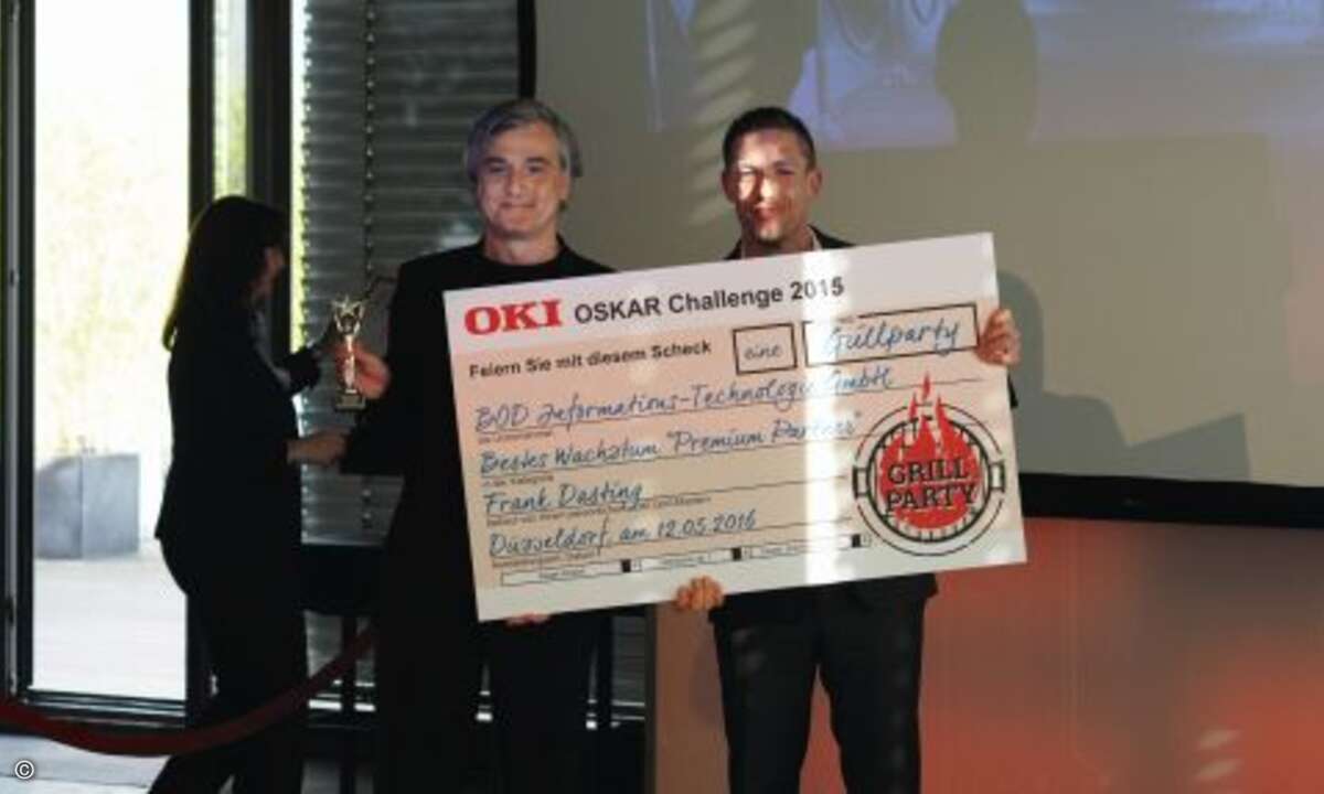 Patrick Keller (links) von »BOD Informations-Technologie« erhielt für das beste Wachstum bei den Premium-Partnern ebenfalls einen Pokal und wird von OKI-Manager Frank Dasting mit Grillgut versorgt (Foto: CRN)