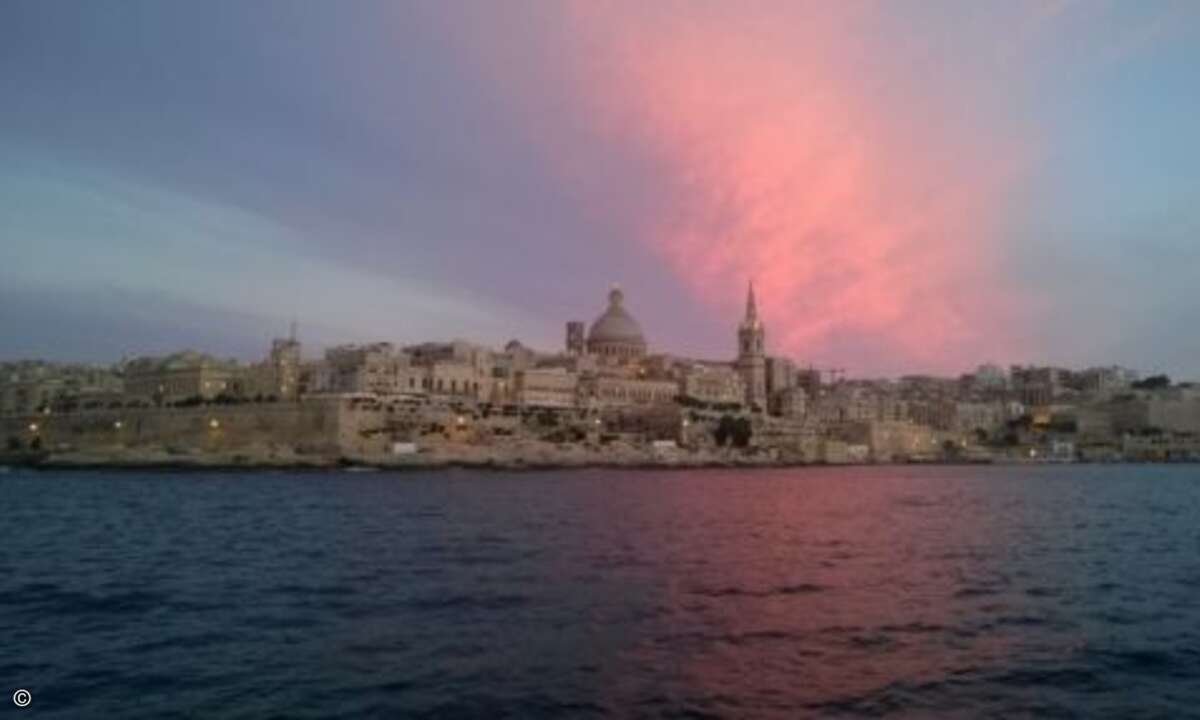 Die untergehende Sonne leuchtet die Wolken über Valletta an (Foto: CRN)