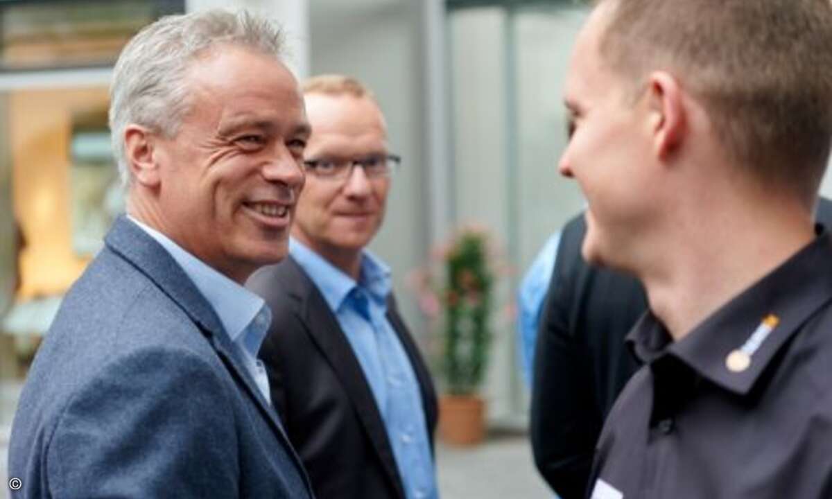 Henning Heimann (li.) und Christian Eisenried von Stemmer unterhalten sich mit Oliver Kügow von Teamix (re.) (Foto: NetApp)