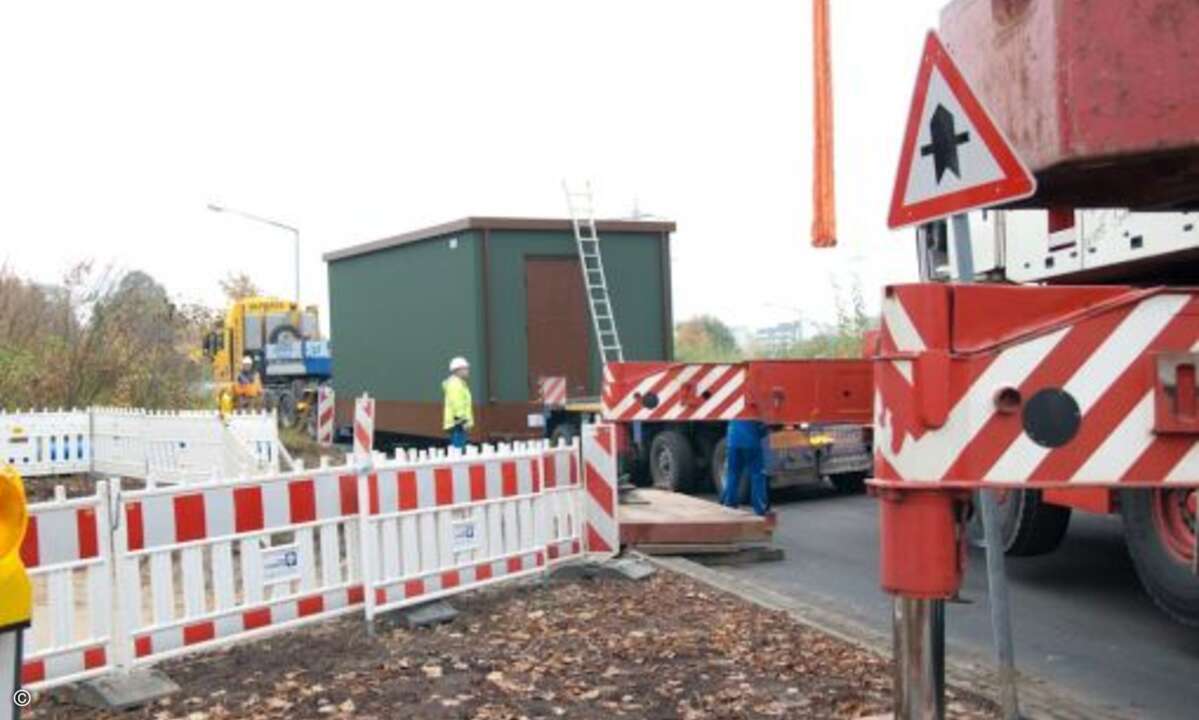 Der 250-Tonnen-Kran von einem Kölner Spezialisten ist in der engen Straße in Position und der Tieflader mit dem PoP nähert sich rückwärts. (Foto: KomMITT Ratingen GmbH)