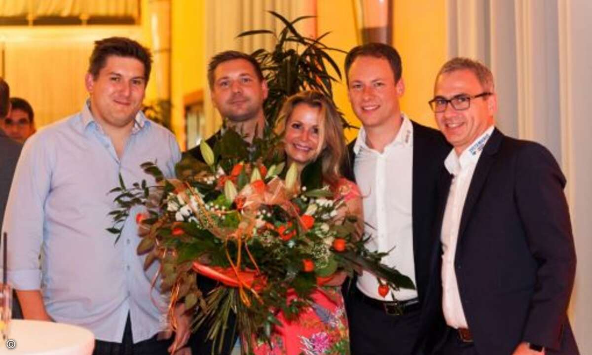 Alexander Münkel (ITscope), Patrick Witton (Docbee), Henning Meyer und Thomas Neumeier übergeben einen großen Blumenstrauß an Isabelle von Künßberg (Foto: Acmeo)