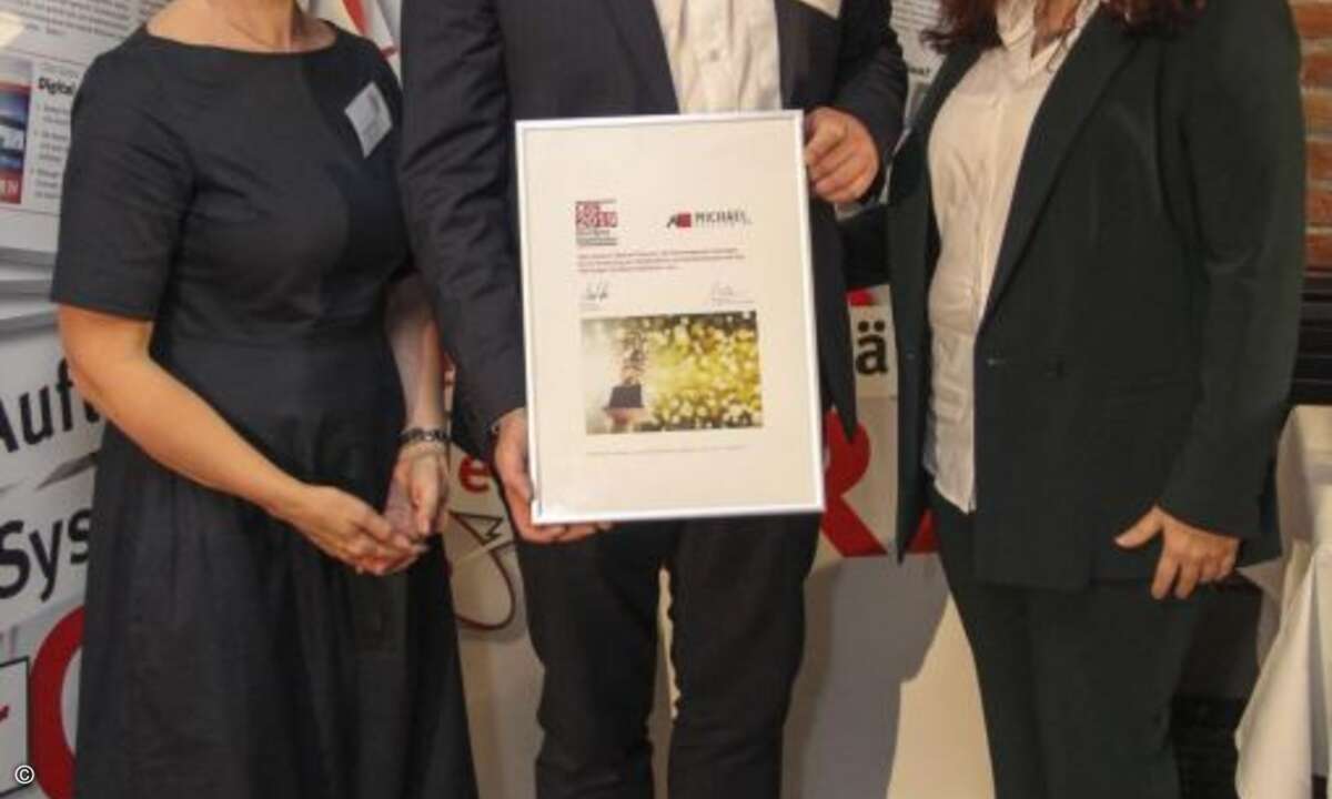 Andreas Schulz und Bianca Hake-Varenkamp präsentieren die Ehrenurkunde für Michael Telecom (Foto: CRN)