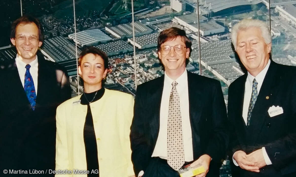 Martina Lübon, Deutsche Messe AG, gibt Microsoft-Geschäftsführer Bill Gates Geleitschutz auf der CeBIT 1995, flankiert von Microsoft Deutschland-Chef Christian Wedell (links) und Hubert H. Lange, Vorstand Deutsche Messe AG