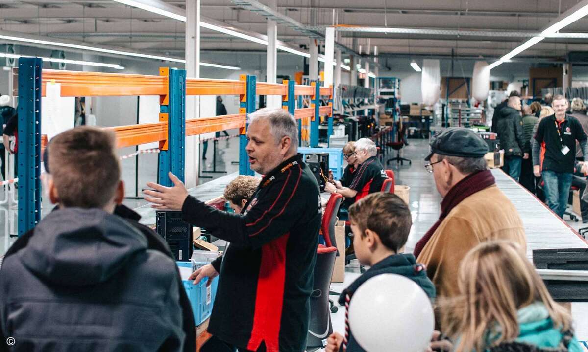 Jörg Fessel (Mitte) führt Gäste durch das neue Lager