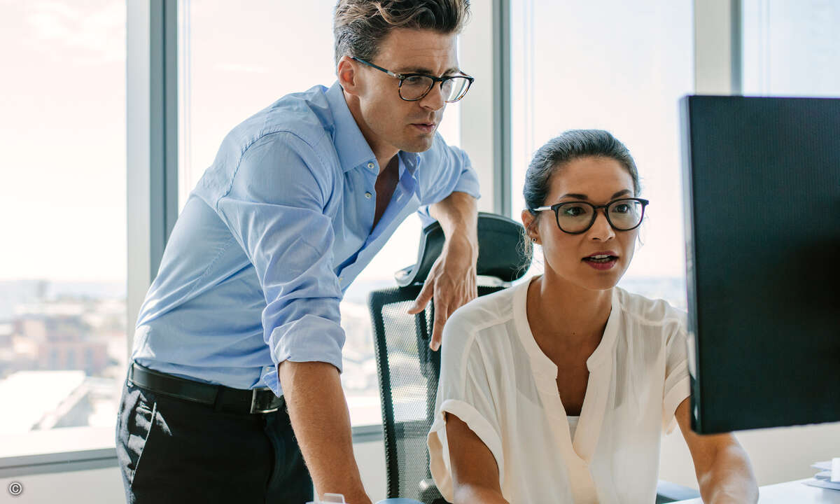 Two corporate professionals working together on computer